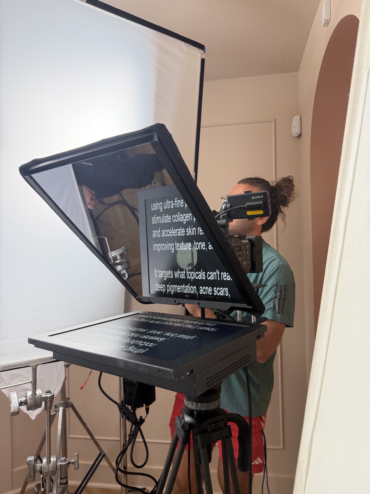 Camera-mount teleprompter with operator on a video production set