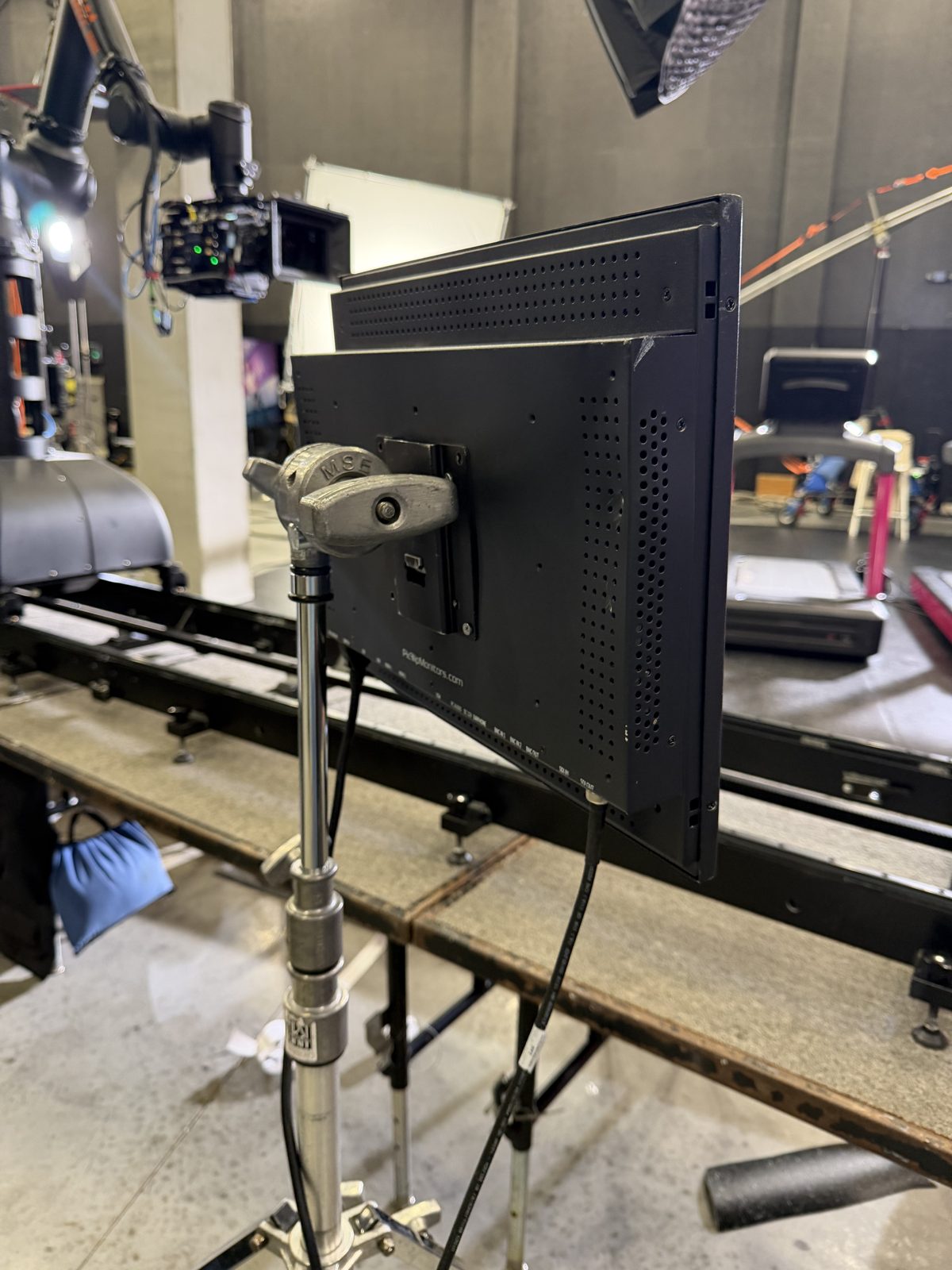 Teleprompter monitor beside a motion-control camera track on a soundstage